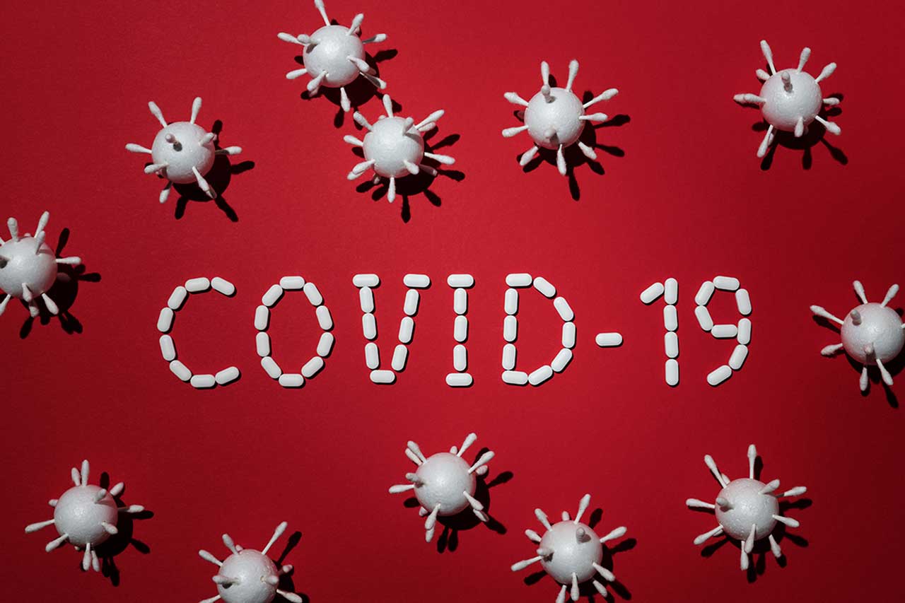 texto covid-19 formado con pastillas con figuras de virus al rededor