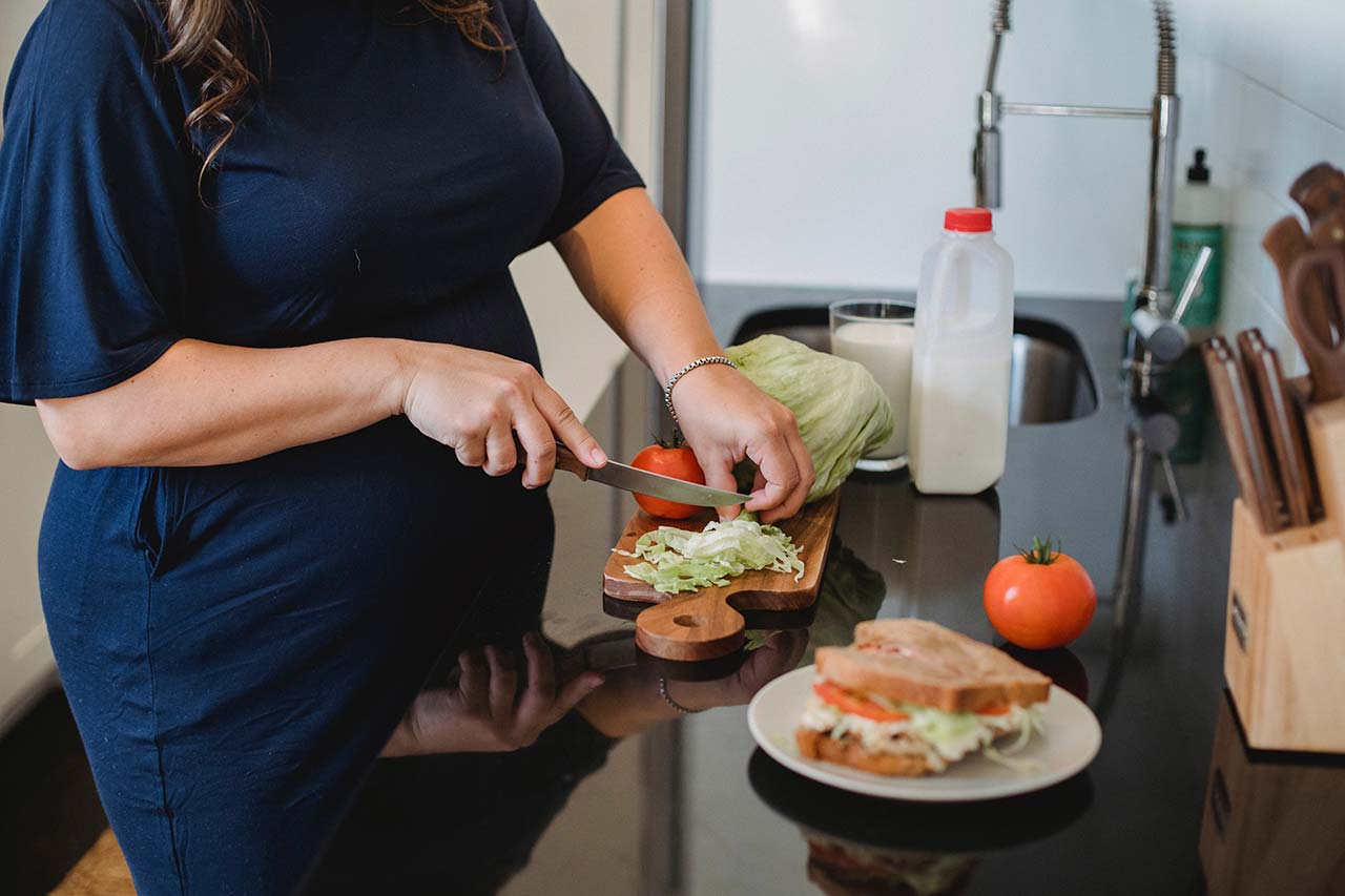 mujer embarazada preparandose un sandwich alimentacion para embarazadas