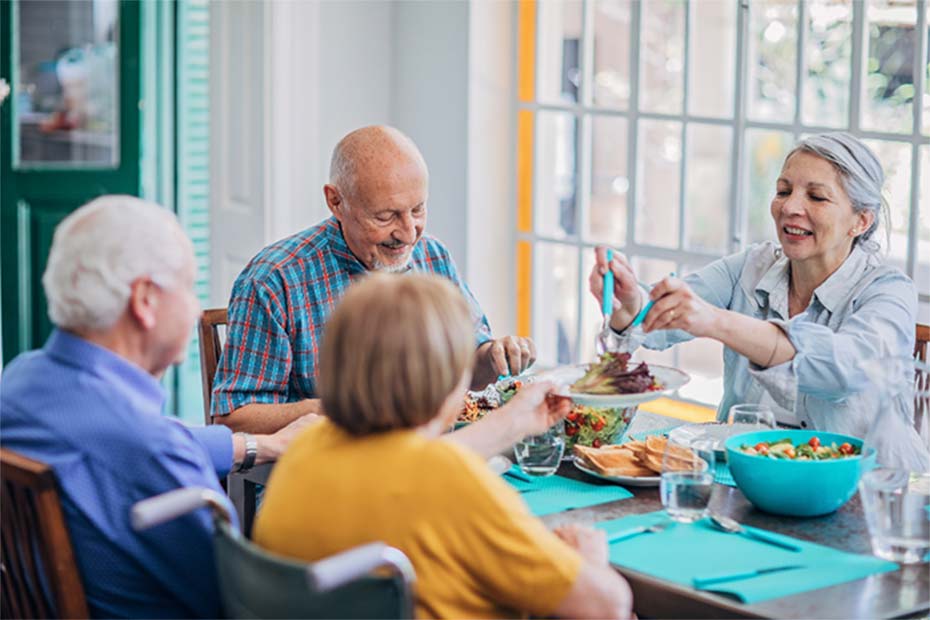 adultos mayores comiendo en un mesa