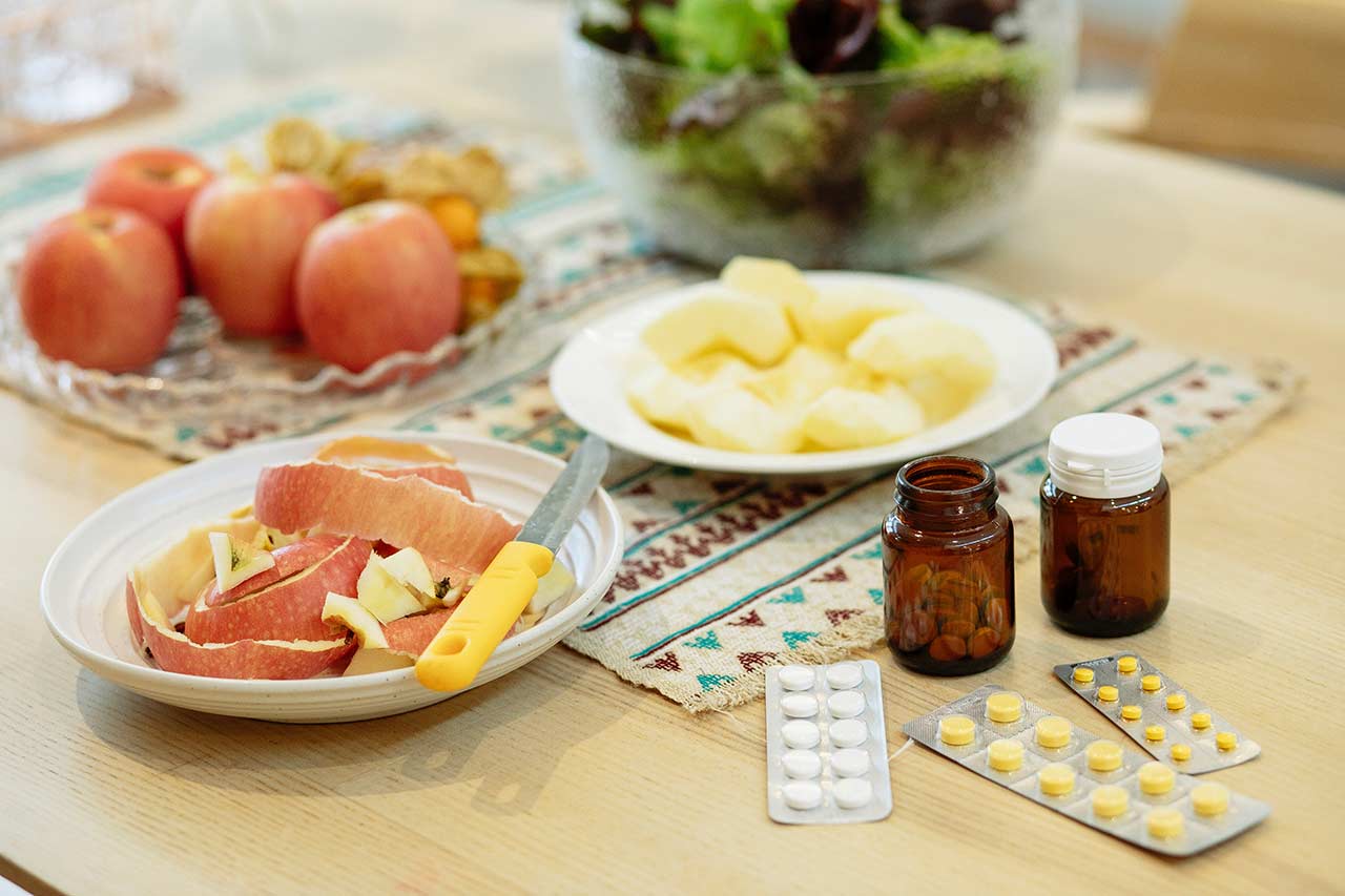 vitaminas para las personas mayores en una mesa con fruta picada
