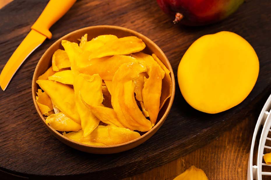 mitad de mango con rebanadas de mango deshidratado en un bol